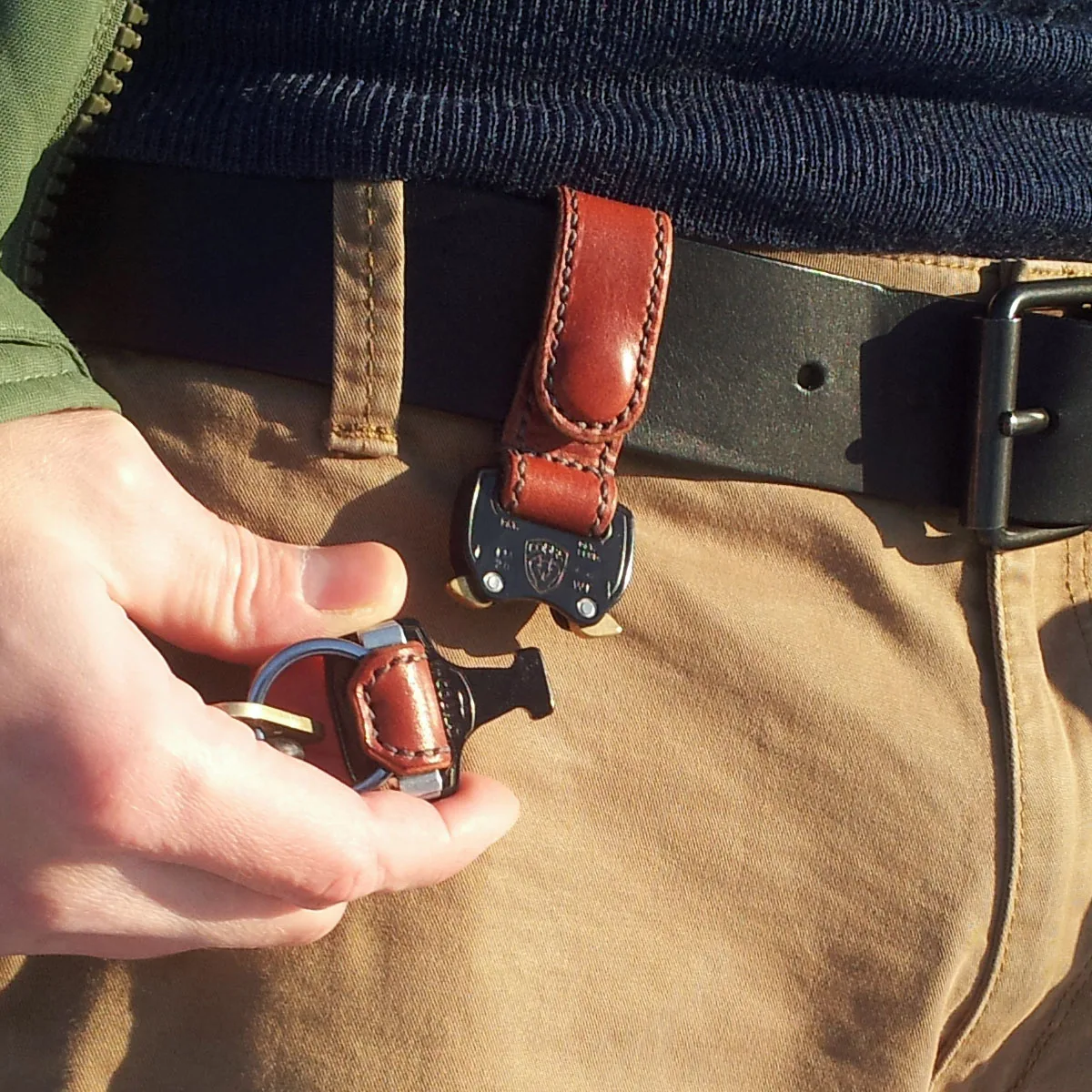 Close-up of the Street Skins leather key holder shown separated into two halves using its COBRA® quick-release buckle.