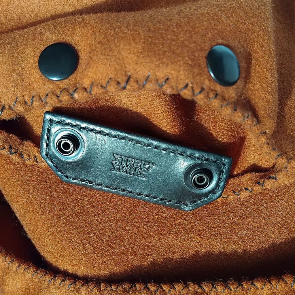 Open pocket of the Street Skins cycling bandana scarf with leather closure and embossed logo.